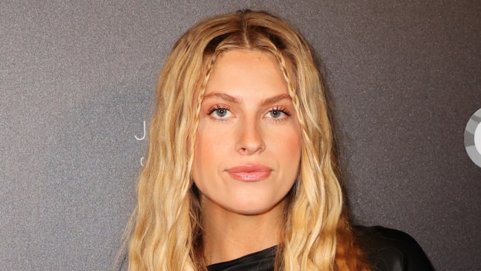 Xandra Pohl poses in a black silk dress and sports her blonde hair in a soft wave.